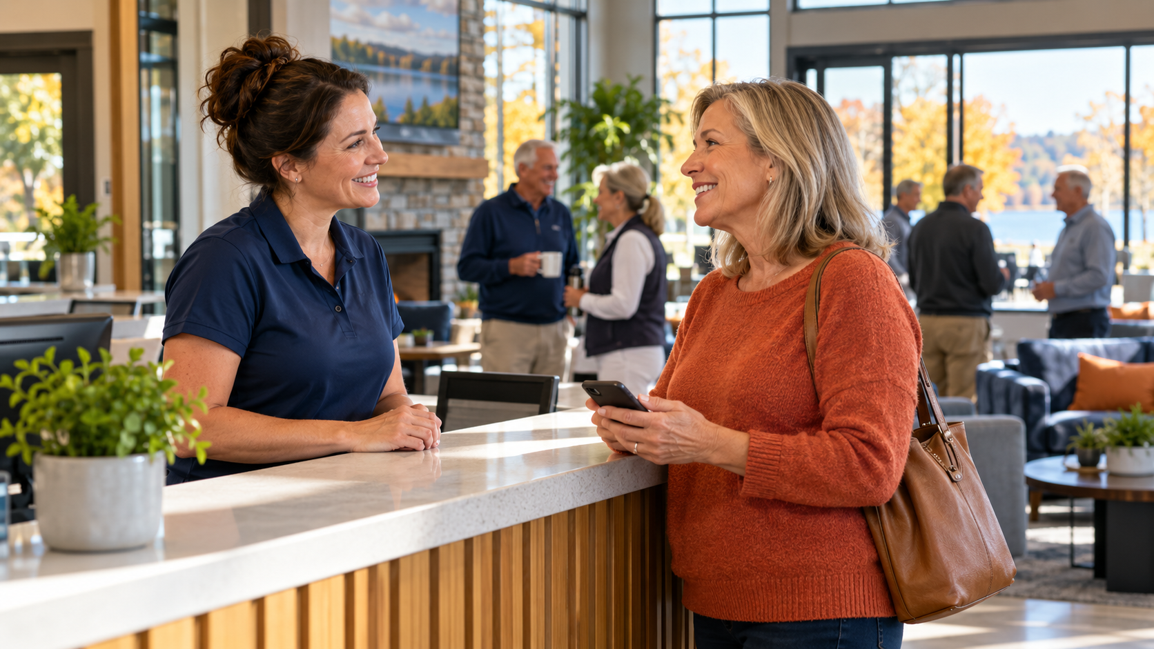 Club staff member welcoming a member holding a phone at the clubhouse reception